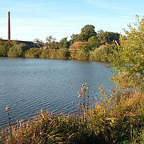 Abgrabungsgewässer – im Hintergrund ist der Schornstein der Ziegelei zu sehen
